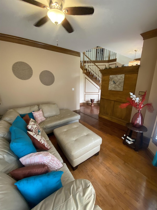 living room featuring hardwood / wood-style floors, ceiling fan, and crown molding