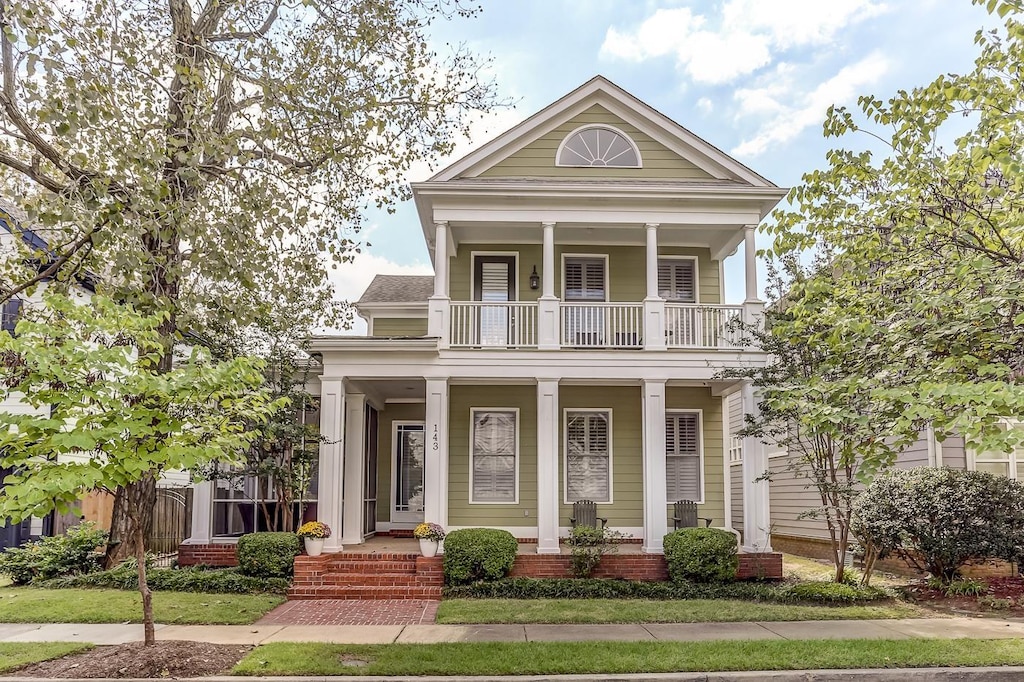 greek revival inspired property featuring a balcony