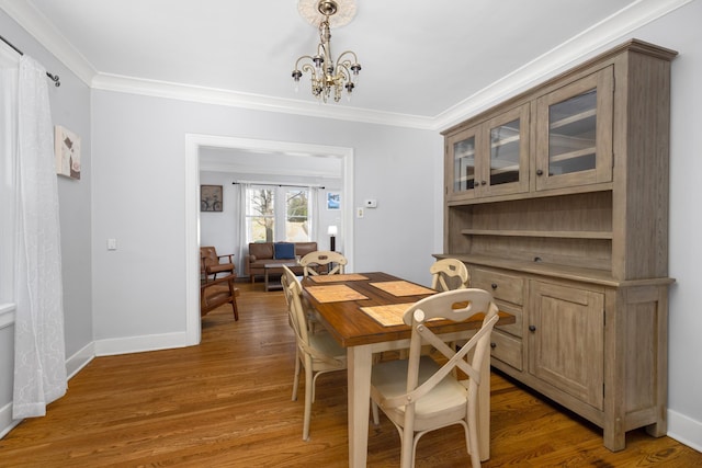 dining room featuring hardwood / wood-style floors, crown molding, and a notable chandelier