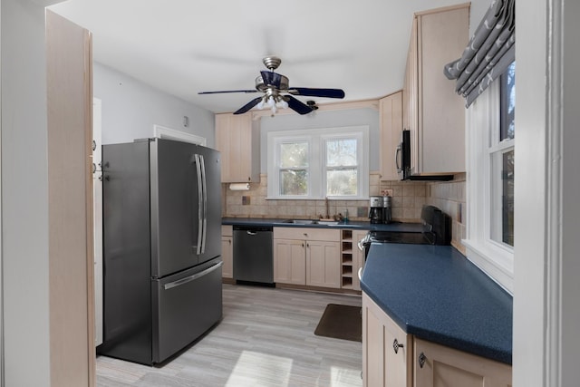 kitchen featuring backsplash, sink, light hardwood / wood-style flooring, ceiling fan, and appliances with stainless steel finishes