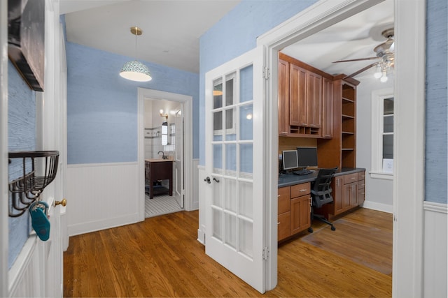 kitchen with dark hardwood / wood-style flooring, built in desk, decorative light fixtures, and ceiling fan