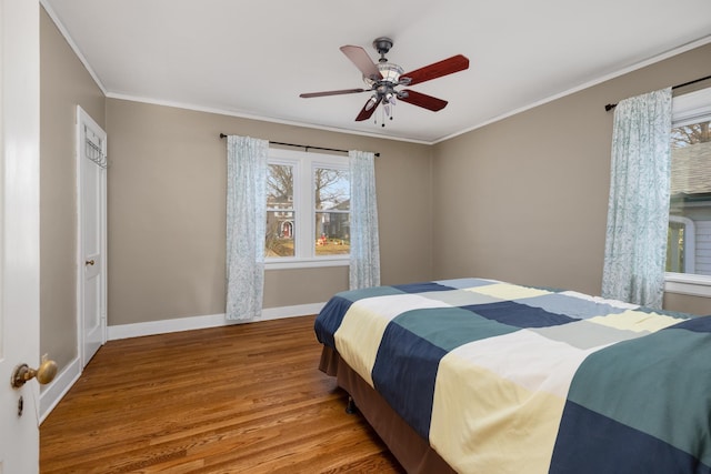 bedroom with ceiling fan, crown molding, and wood-type flooring