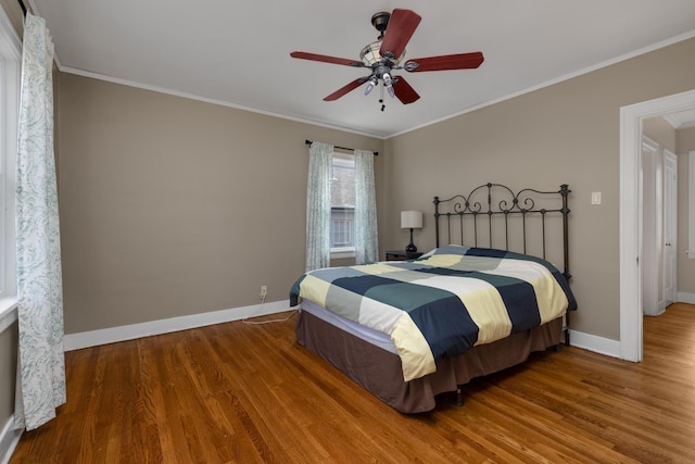 bedroom featuring hardwood / wood-style floors, ceiling fan, and crown molding