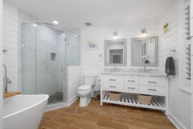 full bathroom with vanity, separate shower and tub, and toilet