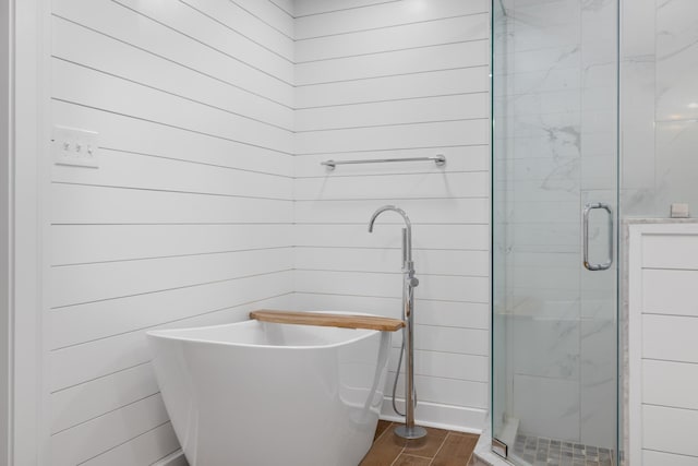 bathroom with shower with separate bathtub and wooden walls