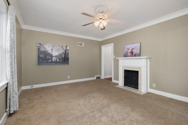 unfurnished living room with ceiling fan, light colored carpet, crown molding, and a tiled fireplace