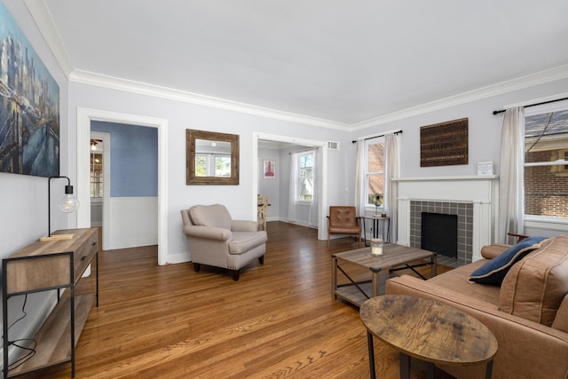 living room with hardwood / wood-style flooring, a fireplace, and ornamental molding