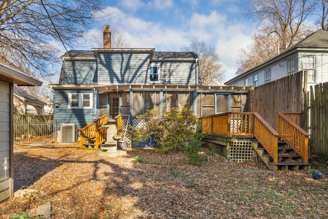 rear view of property with central AC and a sunroom