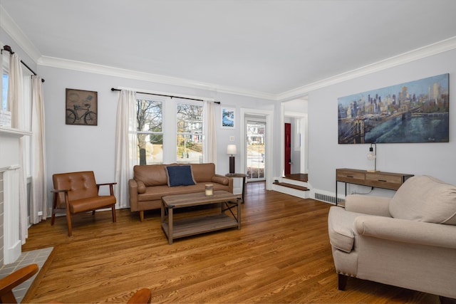 living room featuring wood-type flooring, ornamental molding, and a tile fireplace