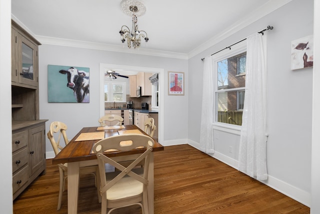 dining area featuring dark hardwood / wood-style flooring, ceiling fan with notable chandelier, and ornamental molding