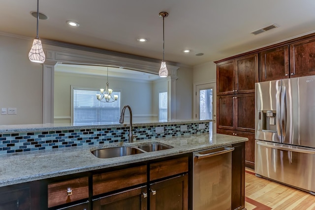 kitchen featuring decorative columns, light stone countertops, and appliances with stainless steel finishes