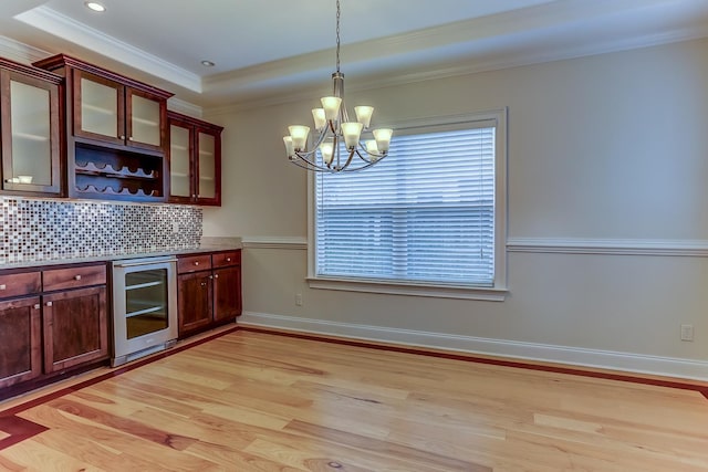 kitchen featuring decorative light fixtures, light hardwood / wood-style floors, wine cooler, and tasteful backsplash