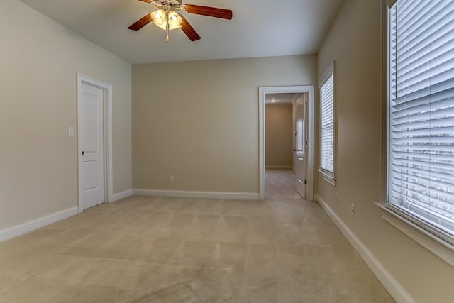 carpeted spare room featuring ceiling fan