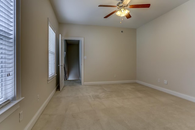 unfurnished room with ceiling fan, plenty of natural light, and light colored carpet