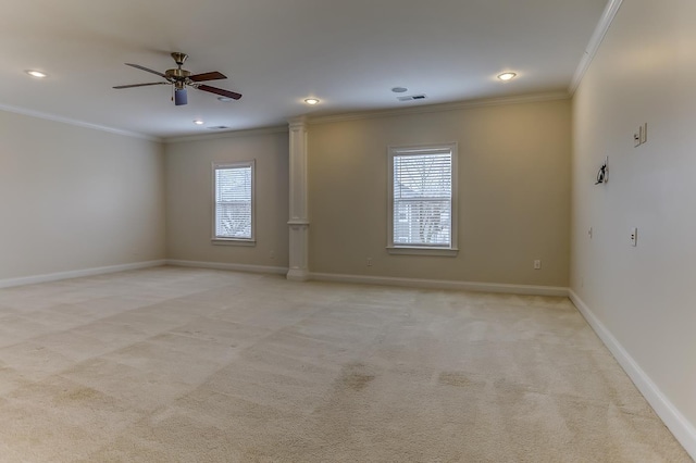 empty room featuring light carpet, crown molding, ceiling fan, and a healthy amount of sunlight