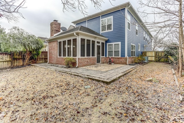 rear view of house featuring a sunroom and a patio area