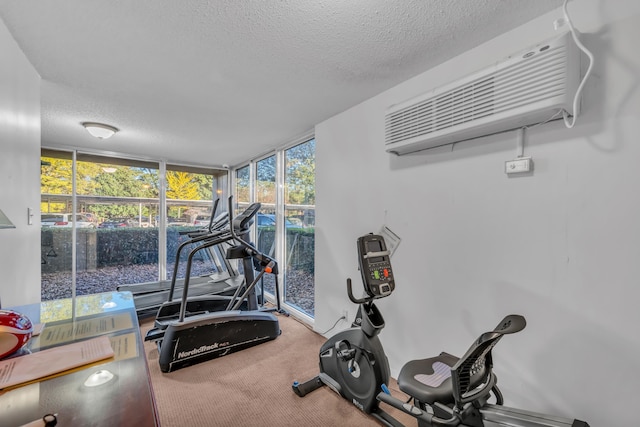 workout room with a wall mounted air conditioner, expansive windows, carpet floors, and a textured ceiling