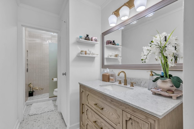 bathroom featuring a tile shower, vanity, toilet, and crown molding