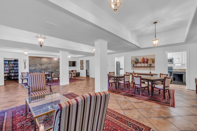 living room featuring a fireplace, light tile patterned floors, and ornate columns