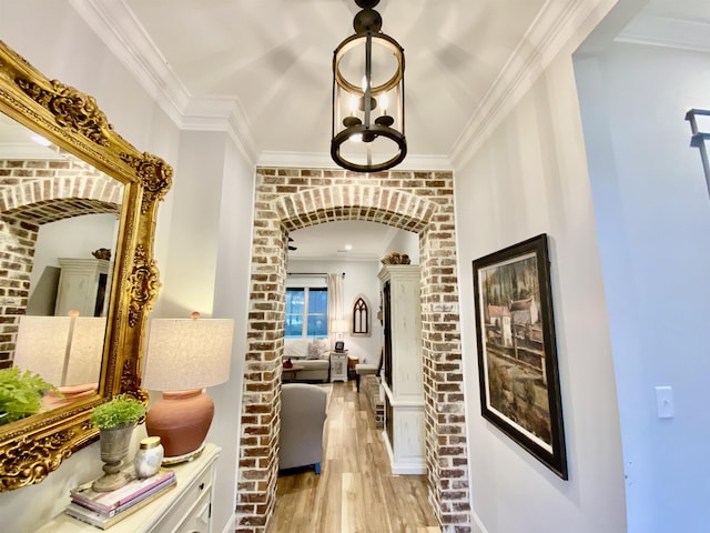 corridor with a chandelier, light hardwood / wood-style floors, and ornamental molding