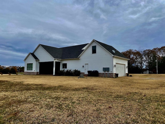 view of side of home featuring a garage and a lawn