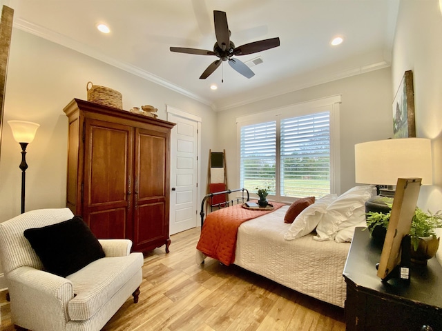 bedroom with ceiling fan, crown molding, and light hardwood / wood-style floors