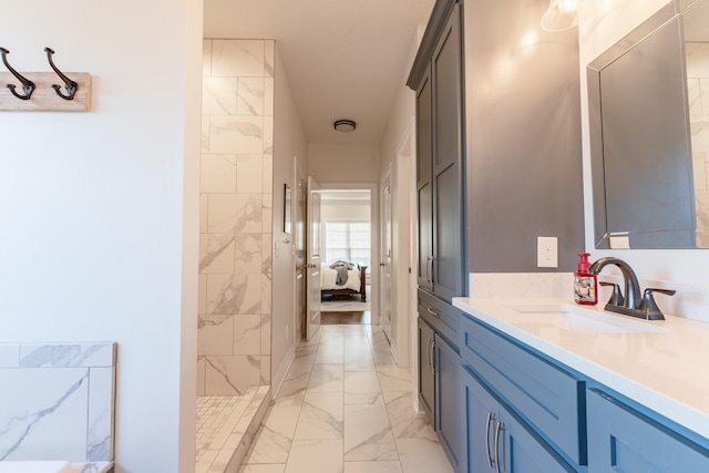 bathroom featuring tiled shower and vanity