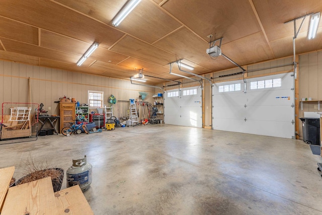 garage with wood walls, wood ceiling, and a garage door opener