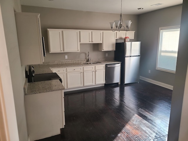 kitchen featuring white cabinets, sink, dark hardwood / wood-style floors, decorative light fixtures, and stainless steel appliances