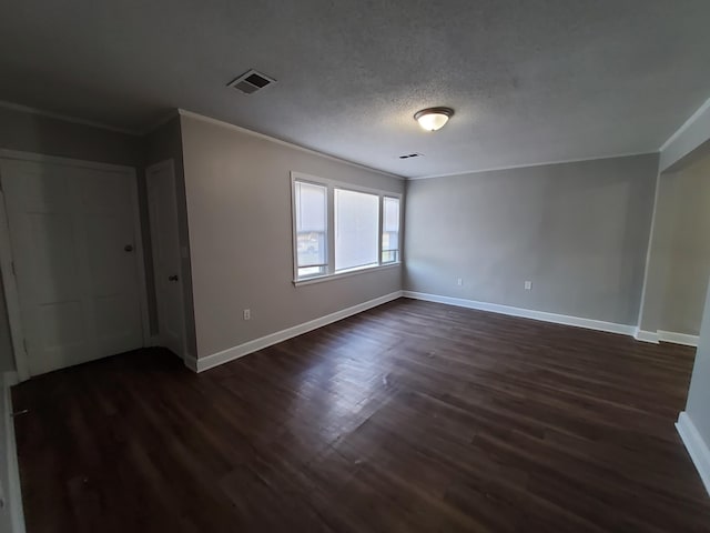 spare room with a textured ceiling, dark hardwood / wood-style floors, and ornamental molding