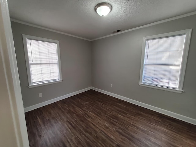 empty room featuring a textured ceiling, dark hardwood / wood-style flooring, and crown molding