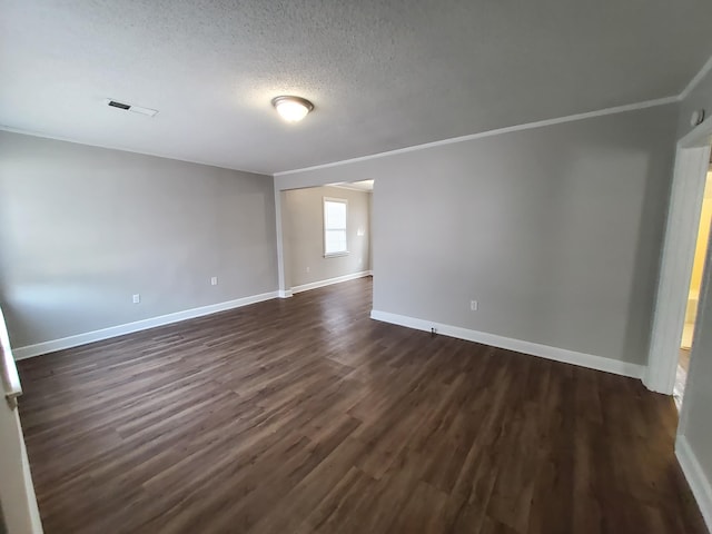 unfurnished room featuring crown molding, dark wood-type flooring, and a textured ceiling