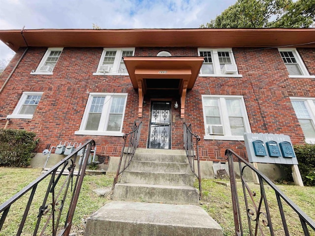 multi unit property featuring cooling unit and a front yard