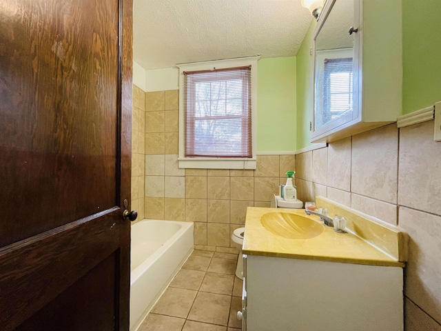 bathroom with a bath, tile patterned floors, a textured ceiling, vanity, and tile walls