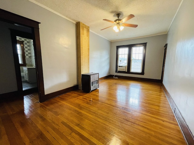 empty room featuring wood-type flooring, a textured ceiling, ceiling fan, and crown molding