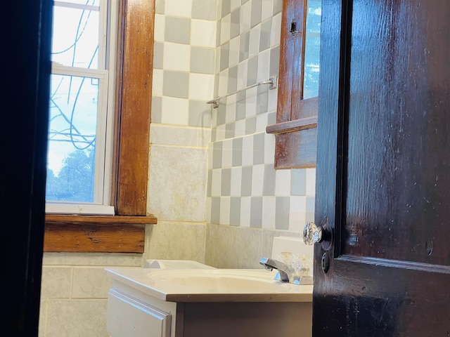 bathroom featuring vanity and tile walls