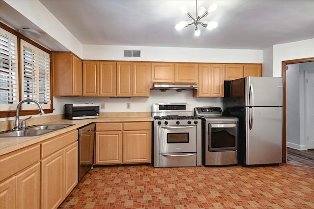 kitchen with sink, washer / dryer, stainless steel appliances, and a chandelier