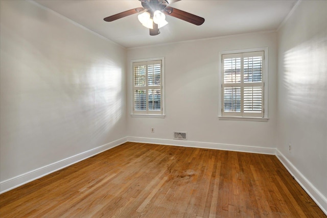 empty room featuring ceiling fan, wood-type flooring, and ornamental molding