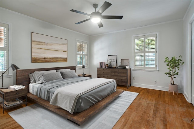 bedroom with ceiling fan, ornamental molding, and hardwood / wood-style flooring