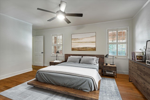 bedroom with multiple windows, ceiling fan, and hardwood / wood-style flooring