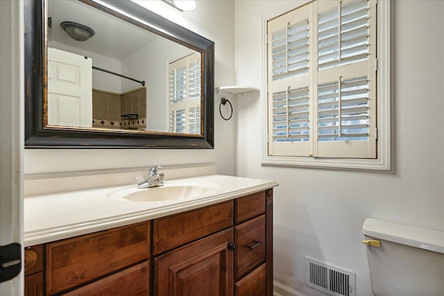 bathroom with a shower, vanity, and toilet