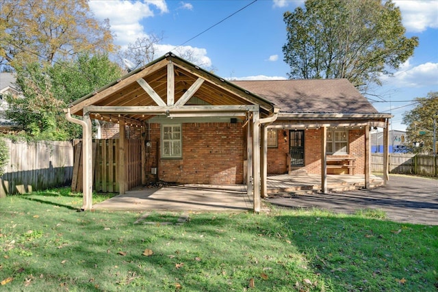 back of property featuring a lawn and a patio area