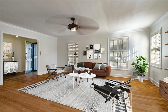 living room featuring hardwood / wood-style floors, ceiling fan, and ornamental molding