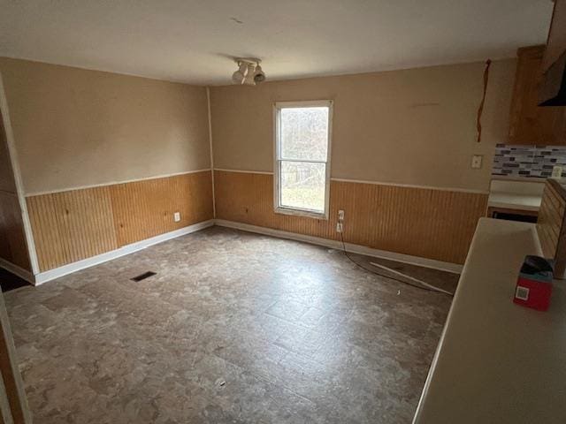 unfurnished dining area with wood walls