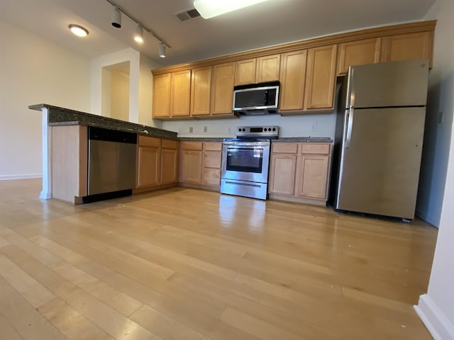 720 Litty Ct Unit 102, Memphis, TN 38103 - kitchen with light wood-type flooring, stainless steel appliances, track lighting, and dark stone counters