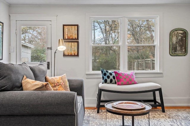 sitting room featuring a healthy amount of sunlight, wood-type flooring, and ornamental molding