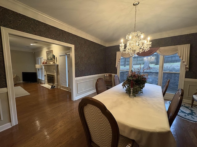 dining space with dark hardwood / wood-style flooring, an inviting chandelier, and ornamental molding