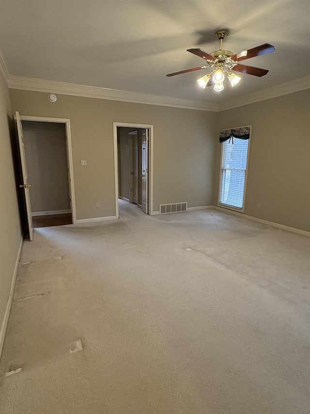 unfurnished room featuring light colored carpet, ceiling fan, and crown molding