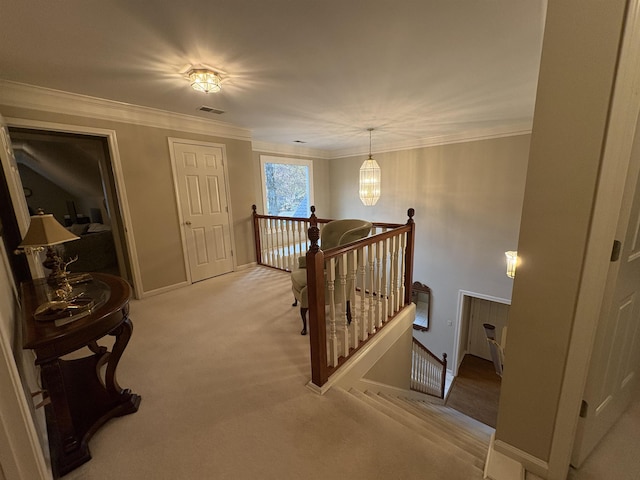 hallway with light carpet, crown molding, and a notable chandelier