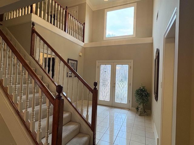 tiled foyer with french doors and a towering ceiling